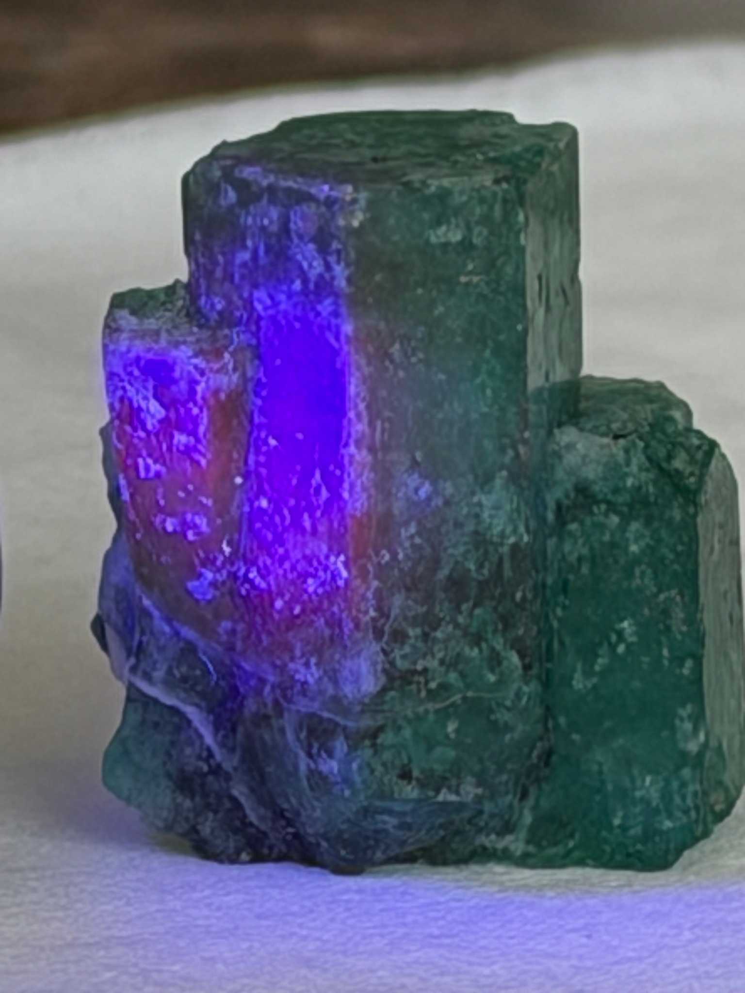 Muzo emerald crystal observed under ultraviolet illumination